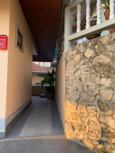 a stone wall in front of a building at Scan House Apartment in Karon Beach
