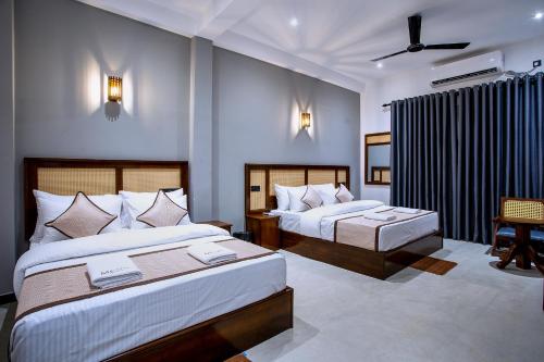 a hotel room with two beds and a chair at Meys Hiriketiya in Dickwella