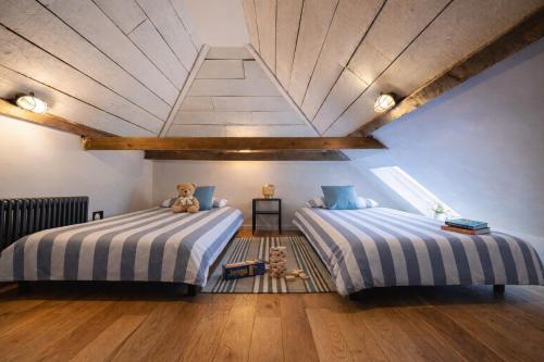 two beds in a room with a wooden ceiling at The Freston Forge in Freston