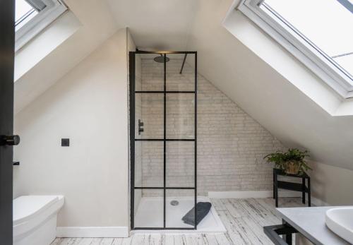 a bathroom with a glass shower in the attic at The Freston Forge in Freston