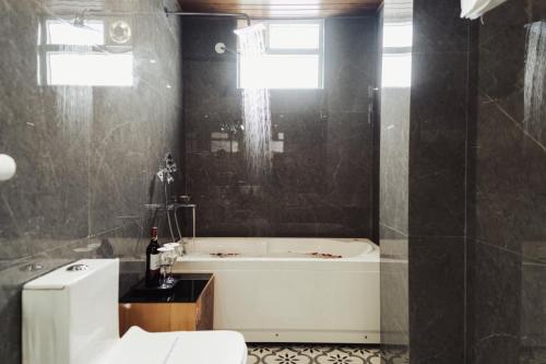 a bathroom with a bath tub and a toilet at Avira Hotel in Gangtok
