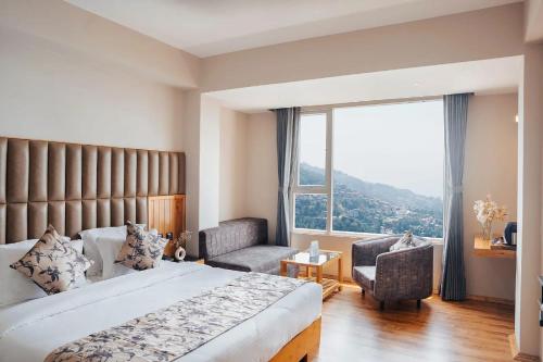 a bedroom with a bed and a large window at Avira Hotel in Gangtok
