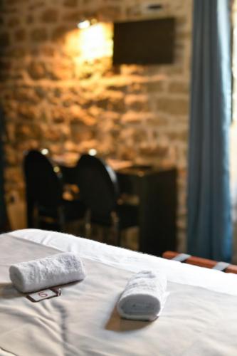 two towels on top of a bed in a room at Le lieu in Saint-Amour