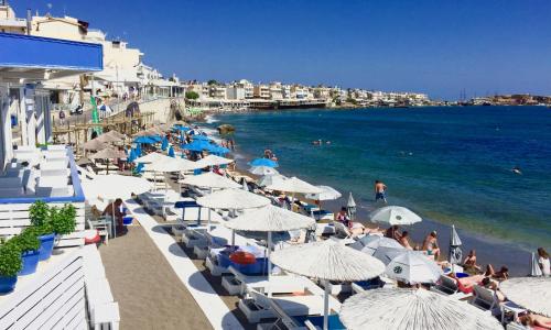 a beach with a bunch of umbrellas and the ocean at Azure Mare Hotel in Hersonissos