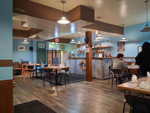a restaurant with tables and people sitting at a bar at The Orca Inn in Alert Bay
