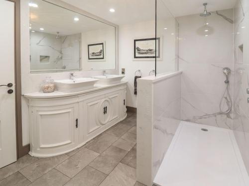 a white bathroom with two sinks and a mirror at 2 Llewelyn Street in Conwy