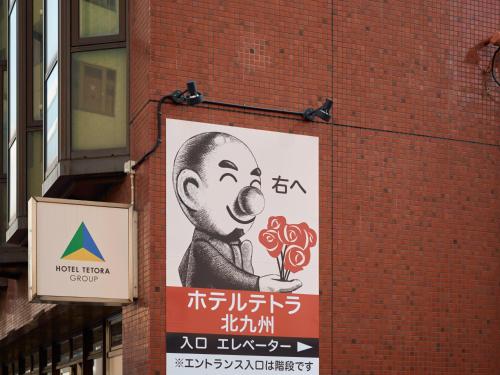 a sign on the side of a brick building at Tabist Hotel Tetora Kitakyushu in Kitakyushu
