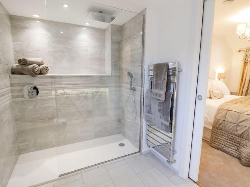 a bathroom with a shower with a glass door at 8 Crown Lane in Conwy