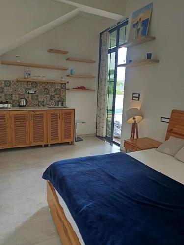 a bedroom with a large bed and a kitchen at The Peace Corgaon in Corgao
