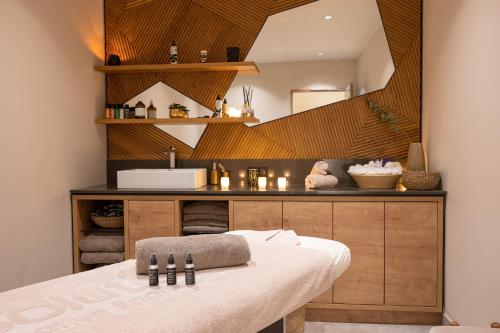 ein Zimmer mit einem Bett, einem Waschbecken und einem Spiegel in der Unterkunft Hôtel VoulezVous by Les Etincelles in Tignes