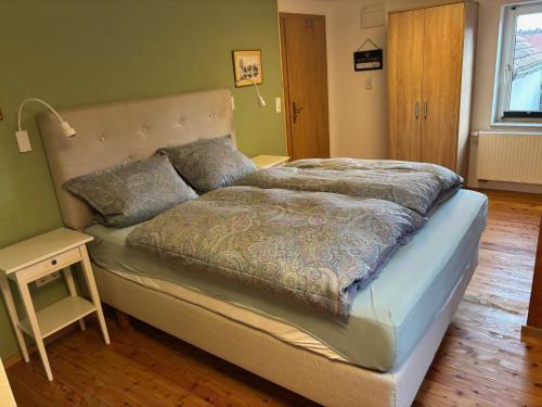 a large bed in a room with a night stand at Ferienwohnung Raabenhorst in Oettingen in Bayern