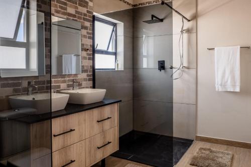 a bathroom with a sink and a shower at Sea Spray Self Catering in Duyker Eiland in Britannia Bay