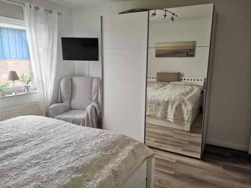 a bedroom with a mirror and a bed and a chair at Wohnung Jolmes in Dahme