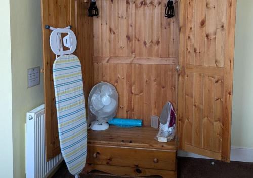 a room with a wooden wall with a surfboard next to a door at Kingswinford Guest House with Free Parking in Paignton