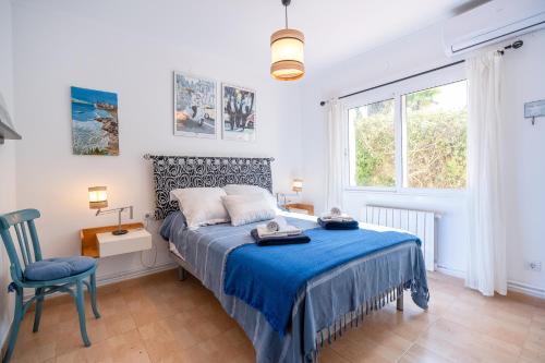 a bedroom with a bed and a chair and a window at Villa Les Moreres de Sitges in Sitges