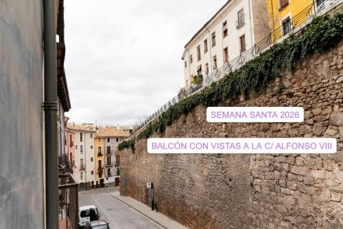 a street sign on the side of a stone wall at La Casa del Orfebre in Cuenca
