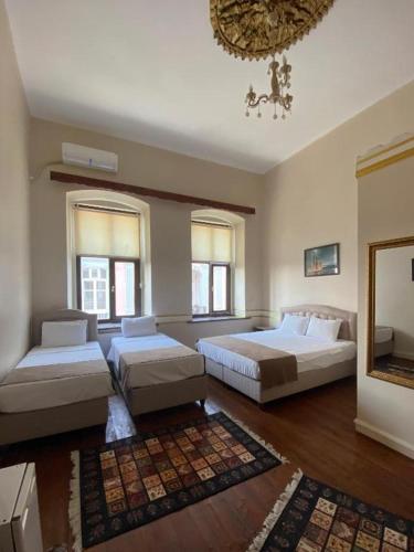 a large bedroom with two beds and a chandelier at Oasis Pansiyon in Edirne