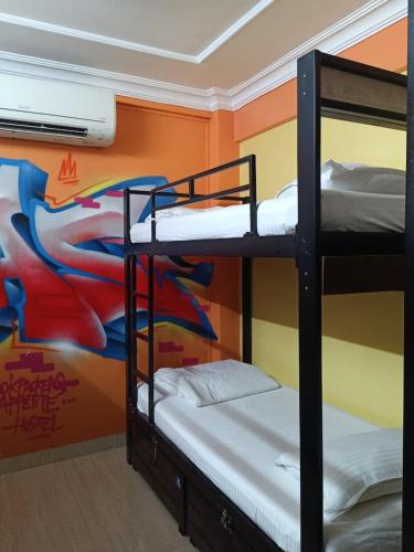 two bunk beds in a room with a mural at The BVM Hostel in Mumbai