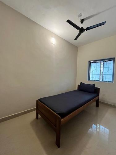 a bedroom with a bed with a ceiling fan at Artjuna CoLiving in Assagao
