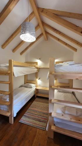 a room with two bunk beds and a chandelier at Pensiunea Dacica in Boşorod