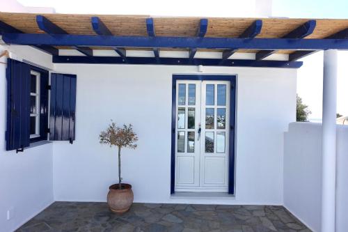 a white house with a white door and a wooden ceiling at Villa D - Kamari Village in Aliko Beach
