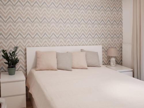 a white bed with two pillows on it in a bedroom at Kis kertes lakás in Pusztavacs