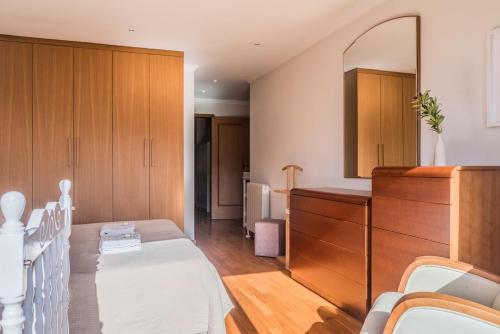 a bedroom with a bed and a dresser and a mirror at Spacious Seafront Residence - Family Friendly in Vila Nova de Gaia