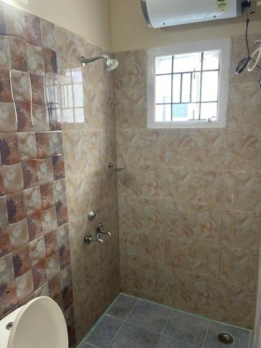 a bathroom with a shower and a toilet at Ooty Peak view villa in Ooty