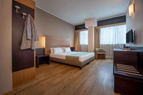 a hotel room with a bed and a television at Golf Hotel Milano in Opera