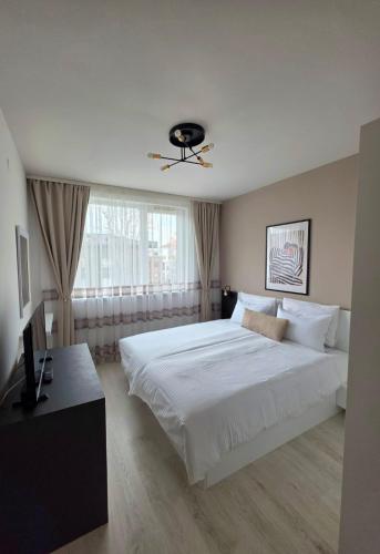 a bedroom with a large white bed and a window at APart Residence Shumen 1 in Shumen