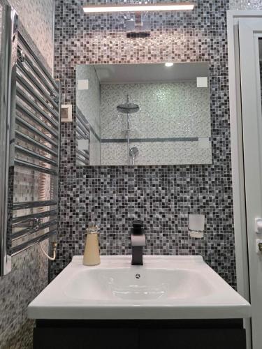 a bathroom with a sink and a mirror at APart Residence Shumen 1 in Shumen