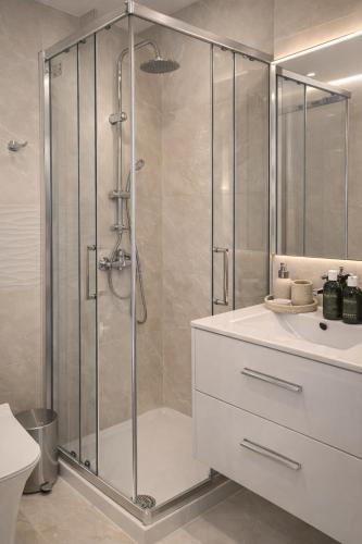 a bathroom with a shower and a sink at Mackenzie Beachfront Panorama in Larnaca