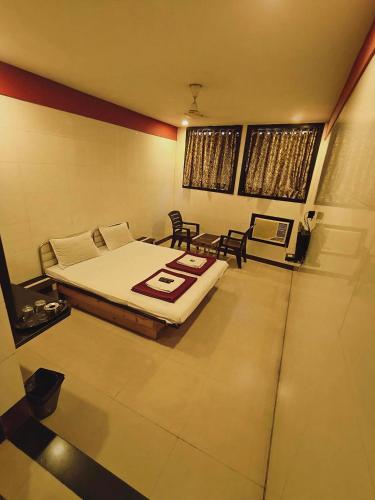 a bedroom with a bed and a table and chairs at Hotel Vishal - Near Surat Railway Station in Surat