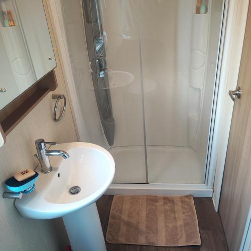 a bathroom with a sink and a shower at Our Retreat By The Waves in Bangor