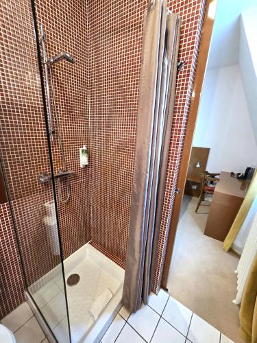 a bathroom with a shower with a glass door at The Originals Boutique, Hôtel Ô Gayot, Bagnoles-de-l'Orne in Bagnoles de l'Orne