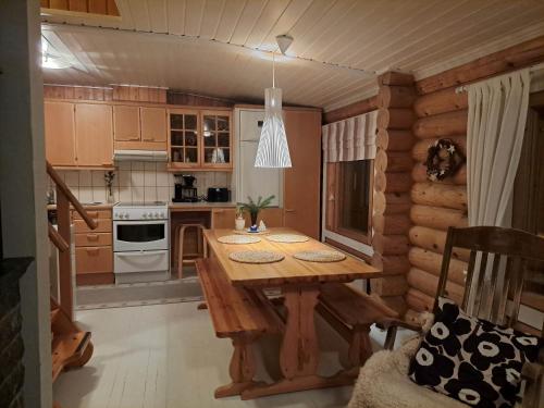 a kitchen with a wooden table in a cabin at Kangasjärvi in Pudasjärvi
