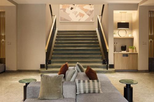 a living room with a couch and a staircase at Eurostars Old Montreal Suites & Apartments in Montreal