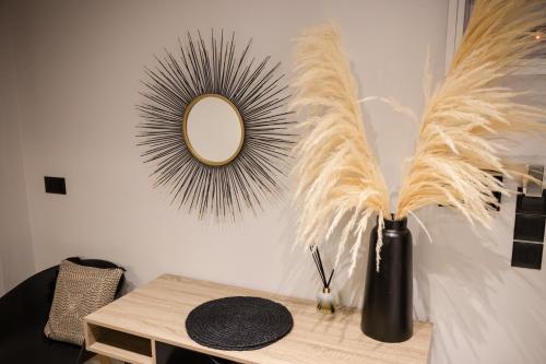 a table with a mirror and a vase with feathers at Loft 77 Patras in Patra