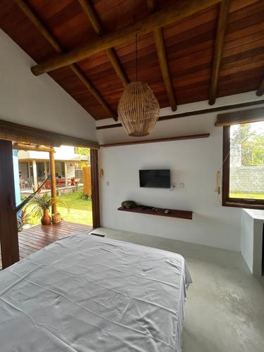 a bedroom with a bed and a tv on the wall at Vila Saquaira in Marau