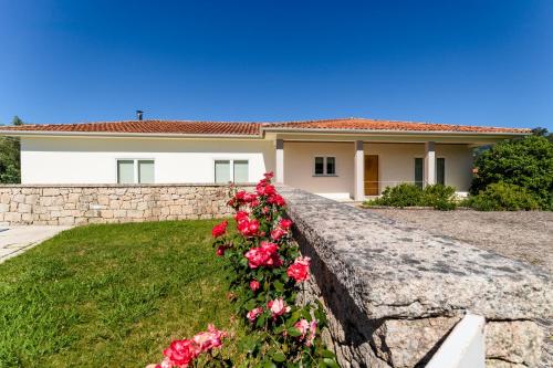 a retaining wall with roses in front of a house at Casa Panorâmica Aurora in Celorico de Basto