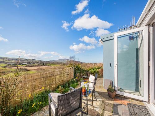 a cottage with a view of the countryside from a patio at Hyfrydle Cottage in Talysarn