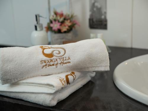 a pile of towels sitting on a counter next to a sink at Swarga Villa in Kandy