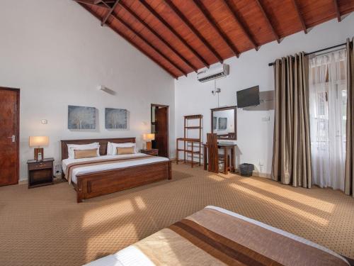 a bedroom with a bed and a television in it at Swarga Villa in Kandy