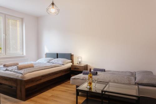 a bedroom with two beds and a coffee table at Apartment Spišská Nová Ves in Spišská Nová Ves