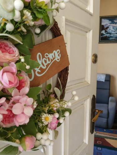a wreath with flowers and a sign on a door at La maison d'Abelleira in Puenteareas