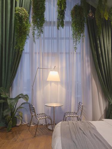 a bedroom with two chairs and a table and a window at Lesi City Guide Hotel in Kyiv
