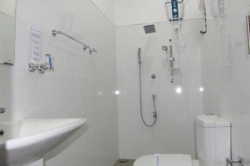 a bathroom with a shower and a toilet and a sink at Rose Lagoon Hotel in Vakarai