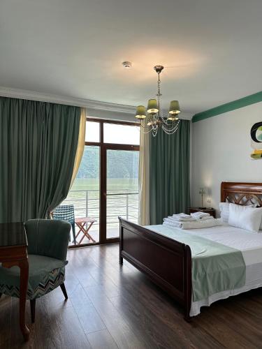a bedroom with a bed and a chair and a window at Riviera 990 - Resort & Restaurant in Eşelniţa