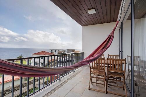 a hammock on a balcony overlooking the ocean at Quinta da Faya in Angra do Heroísmo