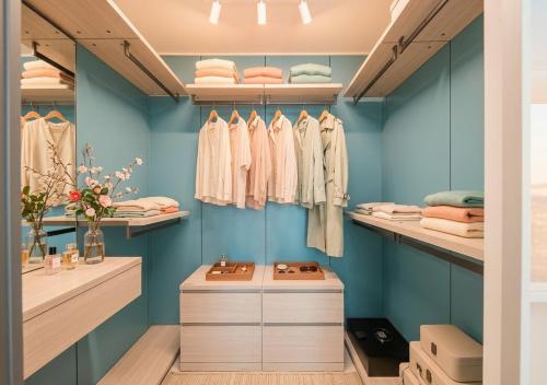 a dressing room with blue walls and shelves at Sota Suite Busan Seomyeon in Busan